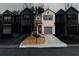 Daytime view of charming townhomes with gray garage doors, paved driveways, and professionally landscaped lawns at 3132 Meadowstone Sw Ln, Atlanta, GA 30331