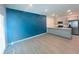 Open-concept living space with modern flooring and a unique blue accent wall near the kitchen bar at 3132 Meadowstone Sw Ln, Atlanta, GA 30331