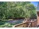 Wooden back deck overlooking a green backyard with mature trees at 5162 Charlemagne Sw Way, Lilburn, GA 30047