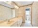 Bathroom featuring a large vanity with double sinks, a large mirror and floral patterned wallpaper at 5162 Charlemagne Sw Way, Lilburn, GA 30047