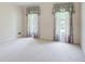 Simple bedroom featuring light-colored walls, carpet and floral print curtains at 5162 Charlemagne Sw Way, Lilburn, GA 30047