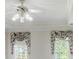 Close up shot of a ceiling fan with lighting and decorative valences on the two windows at 5162 Charlemagne Sw Way, Lilburn, GA 30047