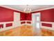 Bright dining room with hardwood floors, red walls, wainscoting, and elegant chandelier at 5162 Charlemagne Sw Way, Lilburn, GA 30047