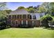 A beautifully maintained two-story brick home with a large, manicured front lawn and mature trees at 5162 Charlemagne Sw Way, Lilburn, GA 30047
