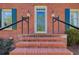 Brick stairway to a front entrance with glass door and matching sconces at 5162 Charlemagne Sw Way, Lilburn, GA 30047