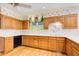 Well-lit kitchen featuring wood cabinets, floral wallpaper, and modern appliances at 5162 Charlemagne Sw Way, Lilburn, GA 30047