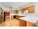 Charming kitchen with floral wallpaper, wood cabinets, white countertops, and hardwood floors at 5162 Charlemagne Sw Way, Lilburn, GA 30047