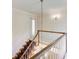 Staircase with stained wood handrail, white risers, and a decorative light fixture overhead at 5162 Charlemagne Sw Way, Lilburn, GA 30047