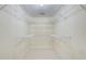 Walk-in closet featuring white walls, white carpeting, and multiple levels of white wire shelving at 5162 Charlemagne Sw Way, Lilburn, GA 30047