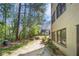 Backyard featuring grassy area, mature trees, and the building's exterior at 89 De Arc Nw Pl, Atlanta, GA 30327