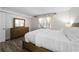 Bright bedroom with a wooden dresser, plush bedding, wood-look flooring, and a window with sheer curtains at 89 De Arc Nw Pl, Atlanta, GA 30327