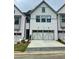 Charming townhome with a painted white brick facade and a two-car garage at 138 Briargate Dr, Johns Creek, GA 30097