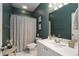 A full bathroom with green walls, a shower with curtain, and a white countertop with sink at 1814 Dupont Nw Ave, Atlanta, GA 30318
