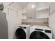 Bright laundry room features new washer and dryer, sleek white cabinets, and convenient shelving for storage at 1814 Dupont Nw Ave, Atlanta, GA 30318
