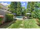 Private backyard featuring a swimming pool, lounge chairs, patio umbrellas, and lush landscaping at 2314 Edgemere Lake Cir, Marietta, GA 30062