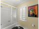 Bright bathroom featuring a shower-tub combo, white subway tile, and plantation shutters at 2314 Edgemere Lake Cir, Marietta, GA 30062