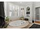 Bathroom featuring a large soaking tub with a window view and built-in shelves for storage at 2314 Edgemere Lake Cir, Marietta, GA 30062