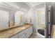Bathroom featuring granite countertops, white cabinets, and double vanity with a framed mirror at 2314 Edgemere Lake Cir, Marietta, GA 30062