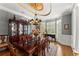 This dining room features a mahogany table, elegant chandelier, and beautiful bay windows at 2314 Edgemere Lake Cir, Marietta, GA 30062