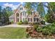 Charming two-story home featuring a stone facade, arched entryway, manicured landscaping, and a circular driveway at 2314 Edgemere Lake Cir, Marietta, GA 30062