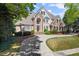 Beautiful home showcasing a manicured lawn, stone accents, and a welcoming curved driveway approach at 2314 Edgemere Lake Cir, Marietta, GA 30062