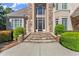 Stately home entrance with stone steps, arched doorway, and lush landscaping at 2314 Edgemere Lake Cir, Marietta, GA 30062