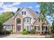 Gorgeous two-story home with stone and stucco exterior and a perfectly manicured front yard in a suburban neighborhood at 2314 Edgemere Lake Cir, Marietta, GA 30062