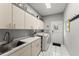 Spacious laundry room with sink, cabinets, washer, dryer, and easy access to outside at 2314 Edgemere Lake Cir, Marietta, GA 30062