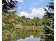 Scenic view of a serene pond reflecting the surrounding trees and sky at 2314 Edgemere Lake Cir, Marietta, GA 30062