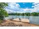 Beautiful lake view featuring a wooden dock with chair surrounded by lush greenery, offering a tranquil lakeside retreat at 315 Monroe Dr, Mcdonough, GA 30252