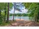 Picturesque view of the lake showcasing a wooden dock framed by lush greenery, creating a serene and inviting setting at 315 Monroe Dr, Mcdonough, GA 30252