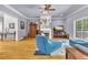Comfortable living room featuring a fireplace, large windows, and beautiful hardwood flooring at 315 Monroe Dr, Mcdonough, GA 30252