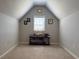 A carpeted attic room with gray walls and a table under the window at 5530 Lacebark Pine Ct, Cumming, GA 30040