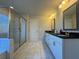 Modern bathroom featuring double sinks, white cabinets, black granite countertops and glass enclosed shower at 5530 Lacebark Pine Ct, Cumming, GA 30040