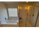 Bathroom featuring a bathtub and shower with white tiling throughout at 5530 Lacebark Pine Ct, Cumming, GA 30040