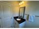 Bathroom featuring a black countertop, white cabinets, and a vanity mirror with decorative lighting at 5530 Lacebark Pine Ct, Cumming, GA 30040