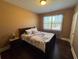 This bedroom features a dark wood floor, a patterned comforter and a window for natural light at 5530 Lacebark Pine Ct, Cumming, GA 30040