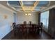 Elegant dining room with coffered ceilings, hardwood floors, and decorative chandelier at 5530 Lacebark Pine Ct, Cumming, GA 30040