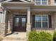 Inviting front entrance with double doors, brick facade, stone pillars, and lush landscaping at 5530 Lacebark Pine Ct, Cumming, GA 30040