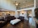 Spacious living room featuring hardwood floors, a ceiling fan, and comfortable leather seating at 5530 Lacebark Pine Ct, Cumming, GA 30040