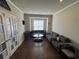 Living room with hardwood floors, neutral paint, and a sitting area in front of a window at 5530 Lacebark Pine Ct, Cumming, GA 30040