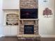 Stone fireplace with built-in shelves and a mounted television in the living room at 5530 Lacebark Pine Ct, Cumming, GA 30040