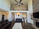 Bright and open living room with tall windows, fireplace, and comfortable leather sofas at 5530 Lacebark Pine Ct, Cumming, GA 30040