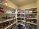 Walk-in pantry with ample shelving space, fully stocked with a variety of food and household items at 5530 Lacebark Pine Ct, Cumming, GA 30040