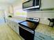 Beautiful kitchen boasts gray cabinets, granite countertops, and a view of the surrounding nature from the window at 8562 Lake Dr, Snellville, GA 30039