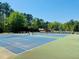 Outdoor tennis courts surrounded by lush greenery, perfect for recreation and sport at 8562 Lake Dr, Snellville, GA 30039