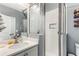 Bathroom showcases a modern glass enclosed shower, white cabinets, a large mirror, and tiled walls at 1324 Cambridge Ave. Sw, Atlanta, GA 30344