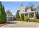 Home exterior showing a detached two-car garage, covered porch, driveway, and landscaped yard at 1324 Cambridge Ave. Sw, Atlanta, GA 30344