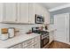 Well-equipped kitchen featuring white cabinets, stainless steel appliances, and quartz countertops at 1324 Cambridge Ave. Sw, Atlanta, GA 30344