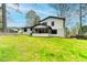 Large grassy backyard with mature trees, lush landscaping, and screened in porch at 1450 Cedarhurst Dr, Dunwoody, GA 30338